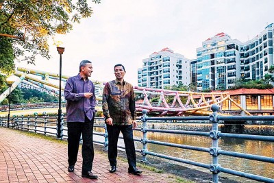 维文（左）与阿兹敏在新加坡河畔散步。