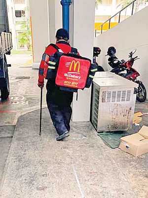 网民目击，一名快餐店送餐员因行动不便，仍需拄着拐杖送餐。