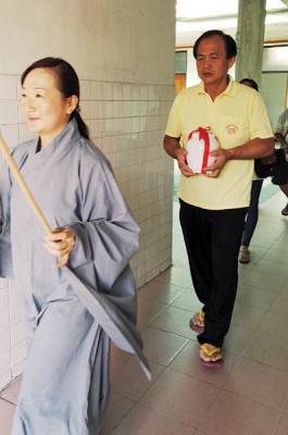 何永发把没有亲属的往生者骨灰奉移到骨灰灵位。