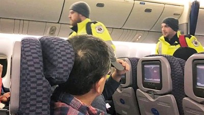 救护员将身体不适的乘客接下机。