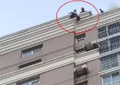 消防员飞身扑救跳楼的小慧。