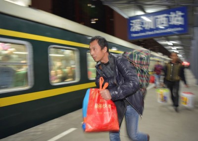 旅客近日拿着一袋二袋的行李赶上列车。