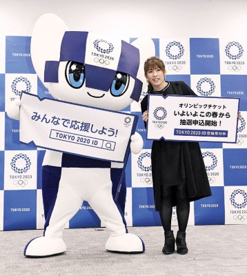 东京奥运会官方吉祥物“miraitowa”和日本女子摔跤奥运会兼前世界冠军吉田沙保里在新闻发布会上现场展示门票销售方式的牌子。