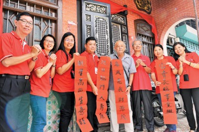 陈国雄(左4)、叶茹妮(左3)、陈靖枂(右2)及施圣提(右3)等在陈氏宗义社贴春联。