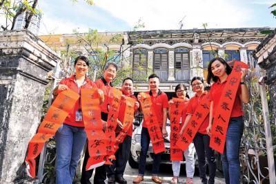本报管理层及职员郑伊玲（右起）、苏美丝、陈美金、叶晓崧、张易雄、邱智坚、黄秋柳一起贴春联。