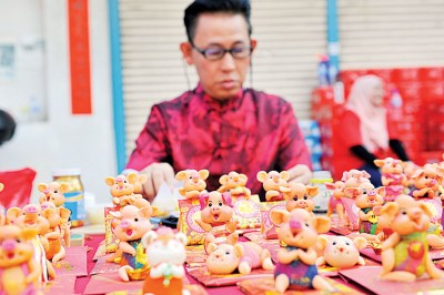 捏面人师傅蔡锦鸿特以猪造型为题材，满桌的“捏面猪”显得格外有趣。