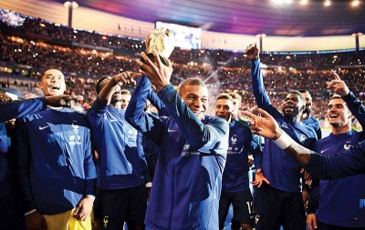 姆巴佩(中)随法国队捧起“大力神杯”，两者都是2018年体坛经典一幕。