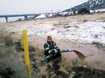 工作人员以水泵将热巧克力浆引入公路旁荒地。