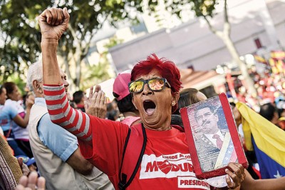 马杜罗的支持者穿上红衣示威。（法新社照片）