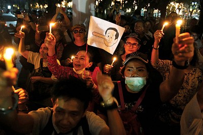 反政府人士周六晚手持印上长了“小木偶鼻子”的泰国首相巴育卡通画像小旗帜，暗讽军人政府没有履行恢复民主制度的承诺。