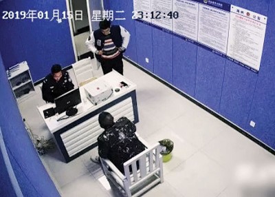 周某接受警方问话。