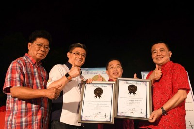 大马纪录大全公司总营运长黄枫伟（左2）颁发大马纪录大全证书予雪隆海南会馆会长丁才荣博士（右），由陈国伟（右2）见证。左为雪隆海南会馆秘书长黄良友。