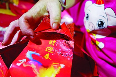 第八：完成后，再次将订好的红包一角往内卷 (如图示)，并以订书器固定。同时，将其余的16红包角重复第八步骤。