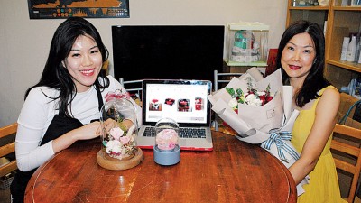 郭珆廷（右）与廖彬如（左）展示玫瑰鲜花及永生花。玫瑰花是情人节主打，永生花后市看起。