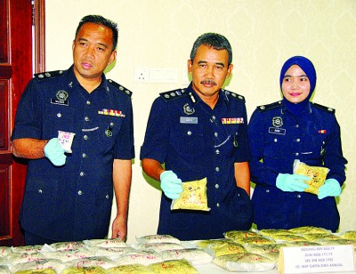 警方侦破美农毒品转运站,起获27公斤重海洛因及冰毒,阿兹里在沙萨里(左)及苏丽达陪同下,出示起获毒品。