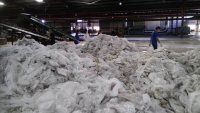 其中一家合法废料厂，员工处理回收的塑料。