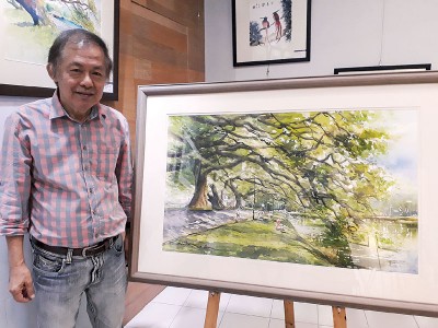 廖新华老师与他笔下的雨树。