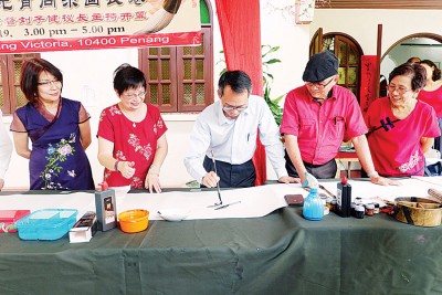 刘子健在张碧殷（左起）、翁丁健、韩彪及会员陪同下，写下春字掀开活动序幕。