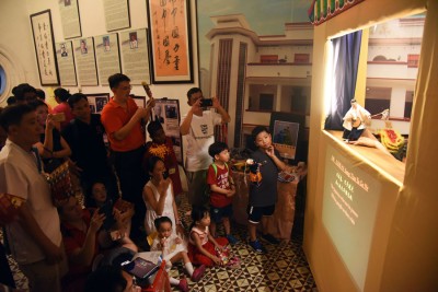 近来少见的皮影戏在庙会吸引不少小孩围观。