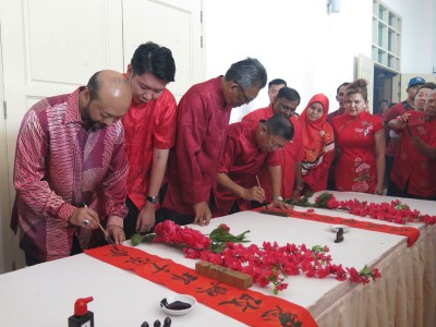 慕克里(左1)与陈国耀(左4)在孟达仑大臣官邸举行的新春活动上为春联填上一笔,左2及左3为黄思敏与依斯迈沙烈。