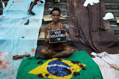 涂上泥巴的受难者家属和民众,周四在圣保罗集会时高举“淡水河谷矿产公司是凶手”的纸牌,要求该公司为惨剧负责。