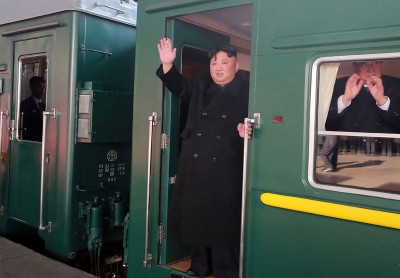 金正恩站在绿色列车车门位置，容光焕发地向月台上的人挥手。（法新社照片） 
