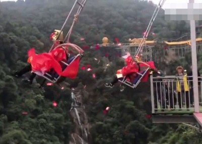2名工作人员扮“财神”坐在千鞦撒下近万封红包。
