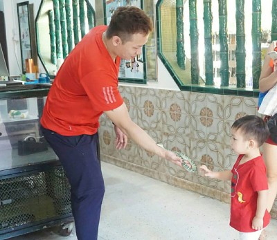 人小胆大,小孩子也敢伸手触摸蛇。