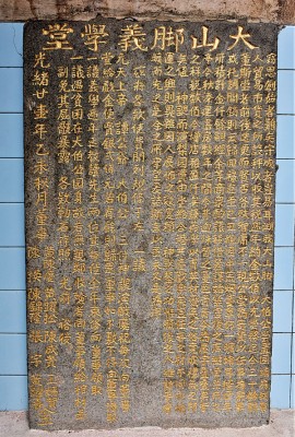「大山脚义学堂」石碑上，黄陈庆名字排在其他人前面。