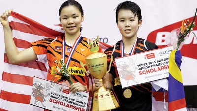 吴堇溦击败师姐李盈盈（左），成为大马首个世青羽赛女单冠军得主，赛后与屈居亚军的李盈盈在颁奖台上欣喜合影。