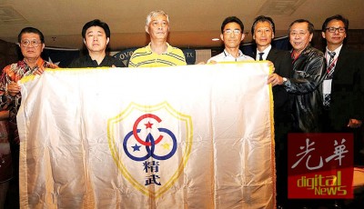 黄保生(左1)在闭幕礼上移交世界精武联谊会大会旗予下届承办国中国余姚市精武体育会会长张宝勇(右4)接领。由温炳楠(右1起),陈清发,周国英,左2起为王国强,薛海荣见证。