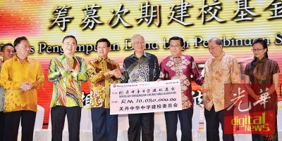 纳吉(中)手持1008万令吉模拟支票,展示此次晚宴为关中次期建校基金募得的数额。左起郑金炎、魏家祥、方天兴、廖中莱、蔡傌友及马珈。