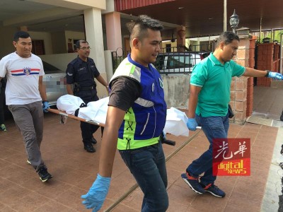 警方人员将死者遗体抬上黑车。
