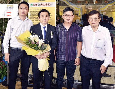 本报副总经理准拿督梁宗宝与广告营业员李雄维祝贺周孙威PJM（左2）受封。