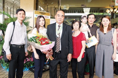 受封DJN准拿督勋衔的李春来与家人及本报广告专员蔡庆意合影。