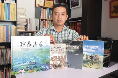 梅德顺展示他所出版的书籍。