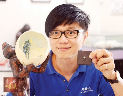陈维铭向记者展示,他以鸵鸟蛋壳及壁虎蛋壳作画的作品。