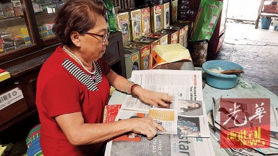 妻子王秀晴闲来无事响应环保拿旧报纸糊纸袋装物品。