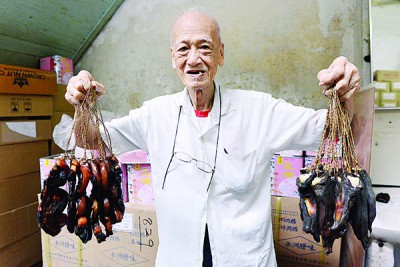 胡树球手中所持的腊味,分别为汾酒曲肉(左)及金银润(右)。
