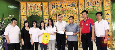 陈小薇（左5）移交帛金义款予受惠单位。左起孙彦彤、孙彦庄、孙靖斐、孙文斐、郑金财、陈泰昌、李富新和孙彦彬 。