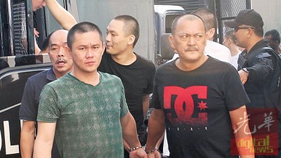 头目许瑞川(右)与其他被告一同被押往新山地庭过堂。