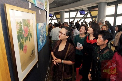 马珈在“天空画廊”欣赏一幅幅由大马女书画家协会带来的画作。