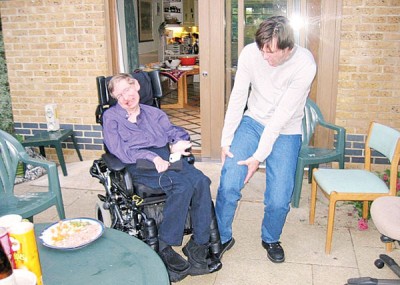 传闻指霍金（左）遇上看不顺眼的人，会装作不小心用轮椅碾过对方的脚。图为美国影星占基利（右）假装被霍金辗到。
