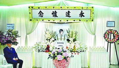 林燕妮儿子李凯豪默默坐在一旁,他送上的粉红色心形玫瑰花圈放在灵堂中央。