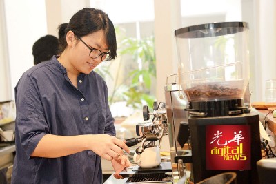 当忙不过来时，洁敏也会帮忙冲泡咖啡，工作中的她时刻展开灿烂笑容感染客人。
