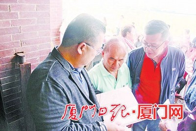 林星发(左)等人一起重看故乡的族谱。