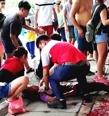 一名男子遭人袭击后，卧倒在地。地面上还有一滩血迹。