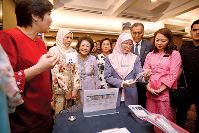 杨巧双(右起)、祖基菲里阿末及旺阿兹莎了解子宫颈抹片检验过程。