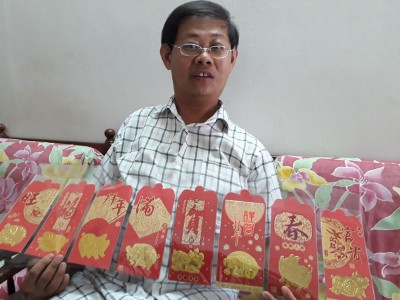蔡棋双展示一套8个猪图案红包封。