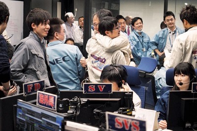 JAXA人员获悉探测器成功降落后，兴奋得互相拥抱。 （法新社照片）